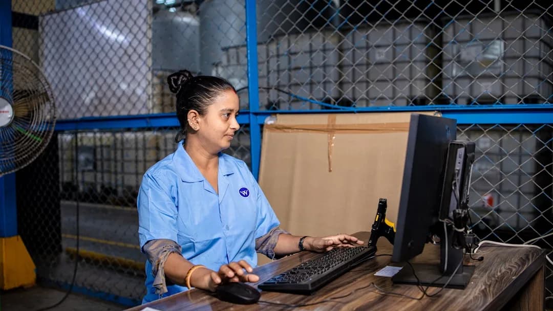 Opératrice d’entrepôt consultant les alertes d’un logiciel logistique sur tablette